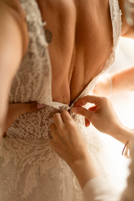 Photographe mariage Dordogne – fermeture robe mariée, mise en valeur par la lumière naturelle